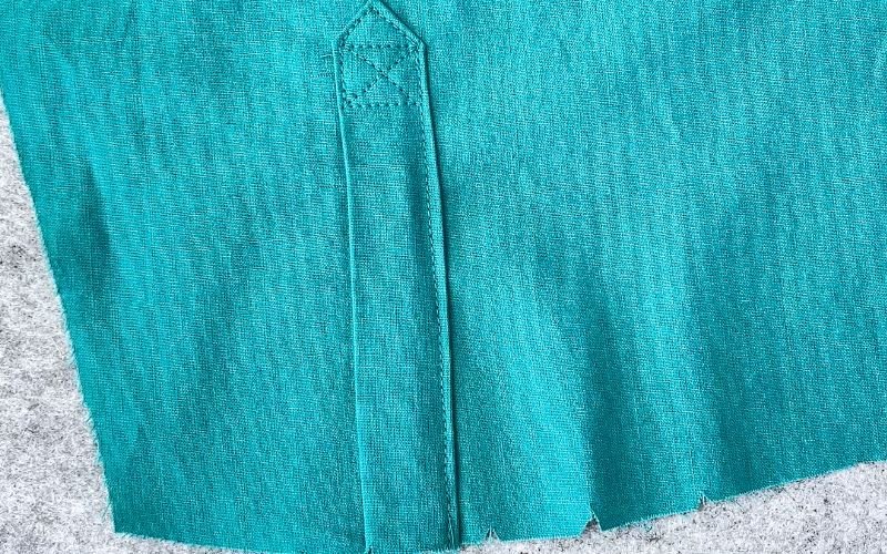 Finished sleeve placket with clean edges, visible topstitching and structured shape