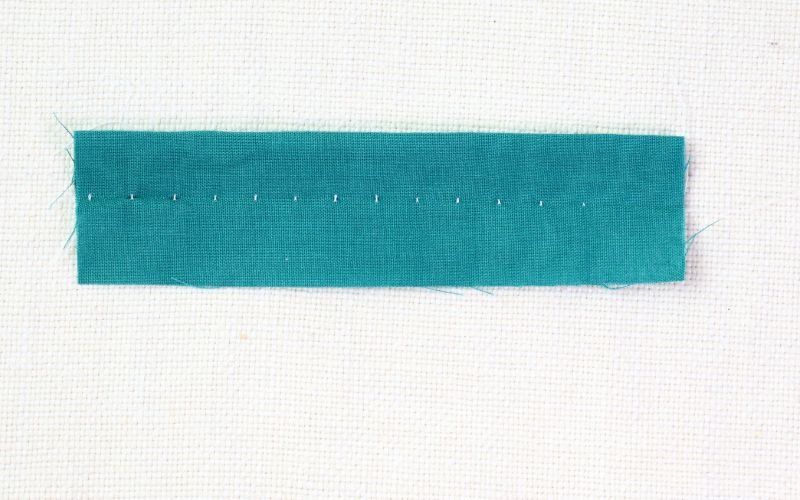 9 Basic Sewing Stitches Every Beginner Must Master Blind hem stitch sample showing a nearly invisible machine-sewn hem on woven fabric