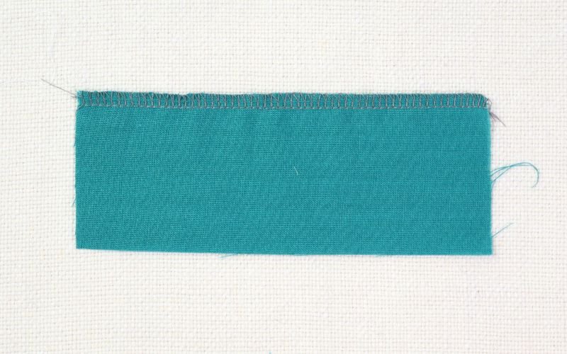 9 Basic Sewing Stitches Every Beginner Must Master Four-thread overlocker stitch sample showing a professional seam finish for woven and stretch fabrics
