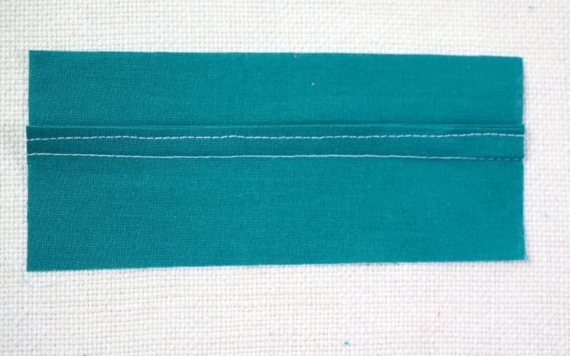 Different Types of Seam Finishes That Look Professional An image of a mock French seam finish, demonstrating how the wider pressed and folded seam allowances are stitched together to mimic the look and raw-edge security of a true French seam.