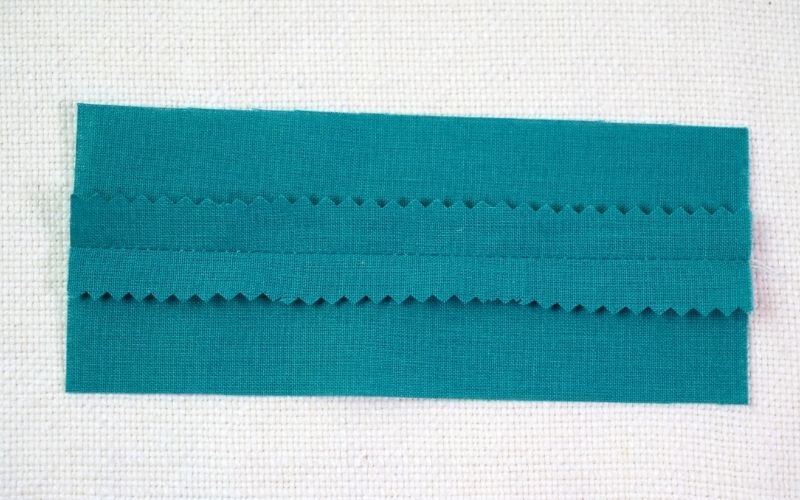 Different Types of Seam Finishes That Look Professional An image of a pinked seam on a stable, dense fabric, demonstrating how the serrated edges created by pinking shears look to provide a simple finish and minimize fraying.